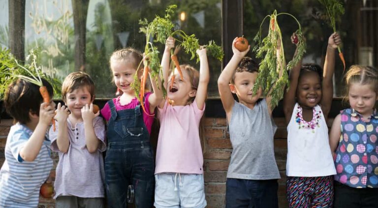 Group,Of,Children,Smiling,And,Holding,Vegetable